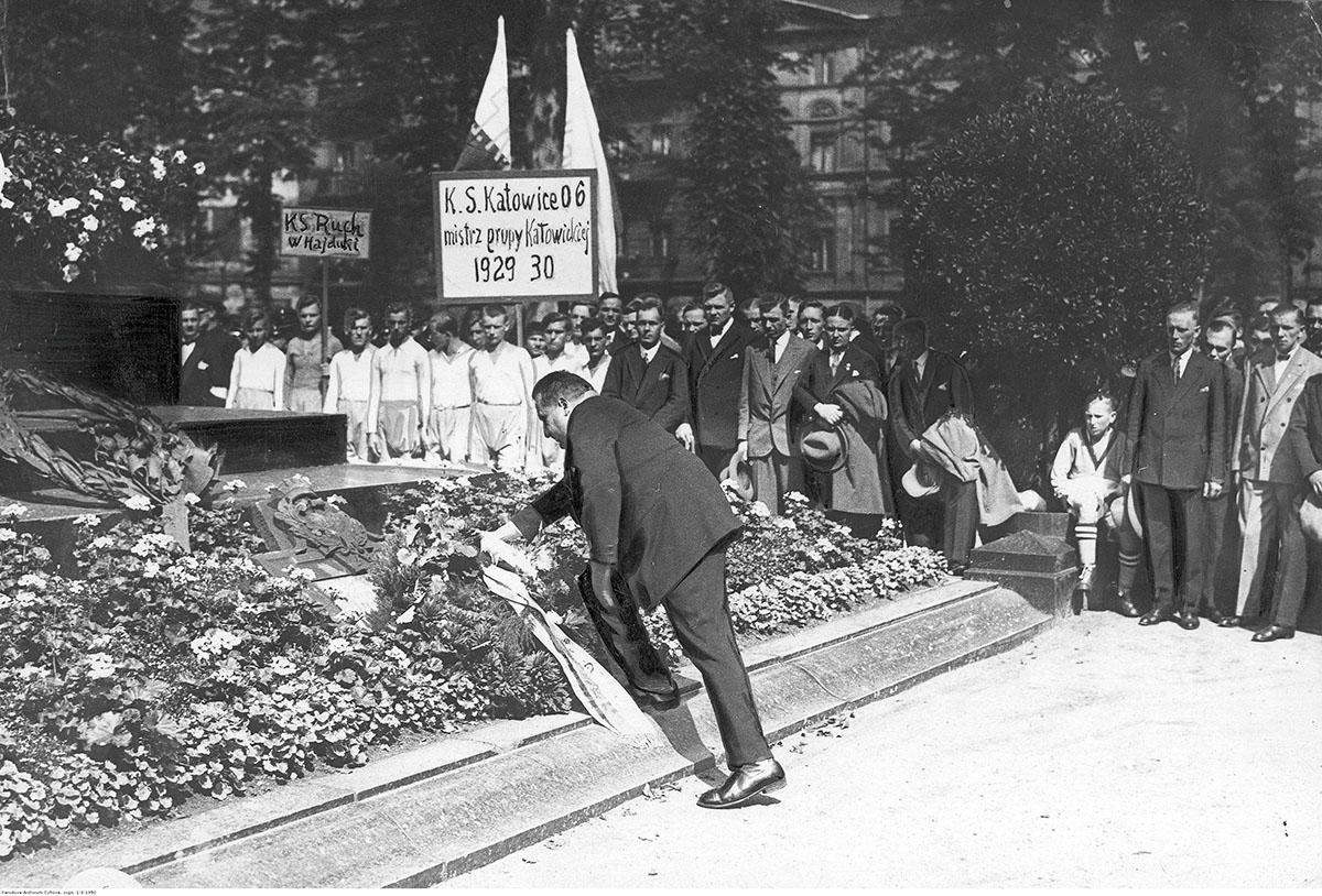 Uroczystość 10-lecia Śląskiego Okręgowego Związku Piłki Nożnej w Katowicach – złożenie wieńca na płycie Grobu Nieznanego Powstańca Śląskiego. Po lewej widoczni przedstawiciele KS Ruch Hajduki Wielkie. Źródło: Narodowe Archiwum Cyfrowe